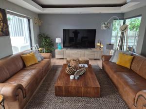 ein Wohnzimmer mit zwei braunen Sofas und einem Couchtisch in der Unterkunft The Compass in Marina da Gama