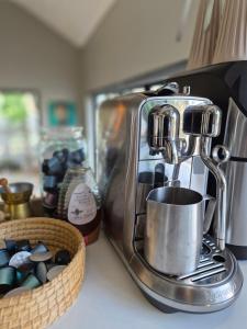 Eine Kaffeemaschine auf einer Theke neben einem Korb mit Steinen. in der Unterkunft The Compass in Marina da Gama