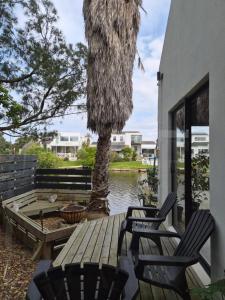 eine Terrasse mit 2 Stühlen und einer Palme in der Unterkunft The Compass in Marina da Gama + 5 Fotos