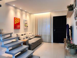 uma sala de estar com um sofá e uma mesa em Casa com Jacuzzi próximo ao teleférico, aquário, Greenvalley e praia! em Camboriú