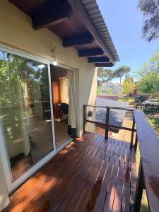 a wooden deck with a view of a patio at Dpto amplio en la naturaleza cerca del mar y del centro de Pinamar in Ostende