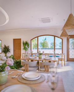 a dining room with tables and chairs and a large window at Noska Hotel in Phu Quoc