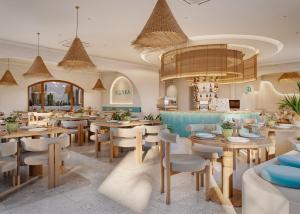 a restaurant with tables and chairs and a chandelier at Noska Hotel in Phu Quoc
