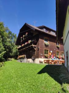 a large brick building with flowers on the balcony at Farmhouse- Bed and Breakfast Kösslergut in Zederhaus