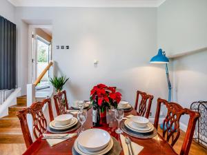a dining room with a wooden table with red flowers at Hillside - Uk48202 in Stockbury