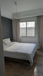 拉巴特L'Adresse Parfaite Rabat Médina Tour Hassan的一间卧室，配有一张大床和一扇窗户。