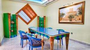 a dining room with a glass table and chairs at Oryx Grand Hotel Jebel Hafeet in Al Ain