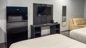 a bedroom with a desk and a tv and a bed at Studio 6 Houston, TX - Westchase in Houston