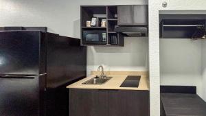 a small kitchen with a sink and a refrigerator at Studio 6 Houston, TX - Westchase in Houston +72 photos