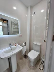 a white bathroom with a toilet and a sink at Guest house marissi in Surami