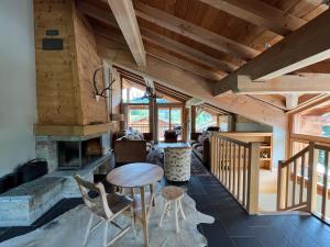 ein Wohnzimmer mit Kamin, Tisch und Stühlen in der Unterkunft Le Cochet by Lodji in Saint-Martin-de-Belleville