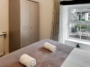 a bedroom with a bed with two towels on it at Parsley Cottage in Tideswell +7 photos