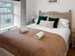 a bedroom with a large bed with two towels on it at Parsley Cottage in Tideswell