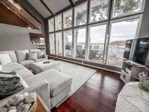 a living room with a couch and large windows at Lakefront Home 5BD3BA DockGrillsDeckKayaks-16 in Sunrise Beach