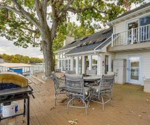 a patio with a table and chairs in front of a house at Lakefront Home 5BD3BA DockGrillsDeckKayaks-16 in Sunrise Beach