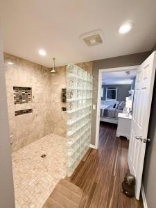 a bathroom with a walk in shower next to a bedroom at Lakefront Home 5BD3BA DockGrillsDeckKayaks-16 in Sunrise Beach +87 photos