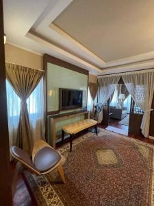 ein Wohnzimmer mit einer Couch und einem Tisch und einem Fernseher in der Unterkunft Perhentian Island CorallView Resort - BlueStar in Kampong Pasir Hantu