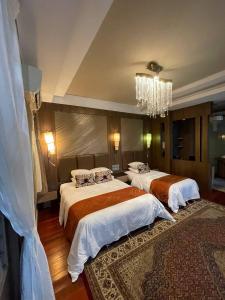 ein Schlafzimmer mit zwei Betten und einem Kronleuchter in der Unterkunft Perhentian Island CorallView Resort - BlueStar in Kampong Pasir Hantu + 97 Fotos