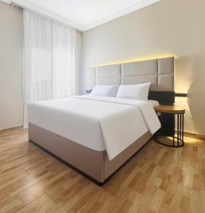 a bedroom with a large white bed and a table at 利恩之家 埃及会展中心 in Cairo +2 photos