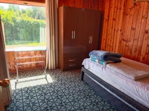 um quarto com uma cama, uma cômoda e uma janela em Cabaña familiar para 6 pax en pucon em Pucón