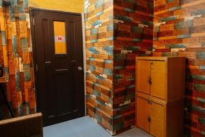 a room with a brick wall with a door at Bụi Homestay - Ferry to Rạch Giá in Rạch Giá
