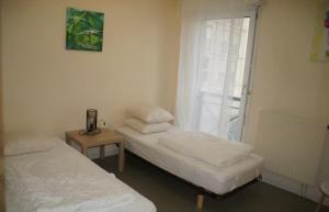two beds in a room with a window at Casa Baïla in Rochefort