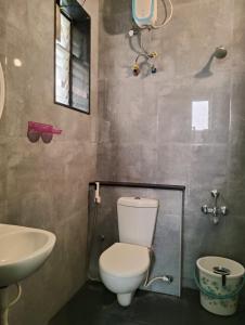 ein Badezimmer mit Toilette und Waschbecken in der Unterkunft Olive Villa ECR - Private 2 BHK villa in Tirupporūr