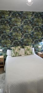 a bedroom with a large bed with a floral wallpaper at Apartamento Cozy Inns Playa in Torremolinos +35 photos
