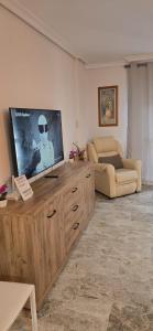 a living room with a flat screen tv on a wooden entertainment center at Apartamento Cozy Inns Playa in Torremolinos