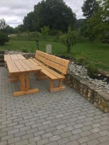 KrobicaにあるPokoje przy strumyczkuのレンガ造りのパティオの上に座る木製ベンチ