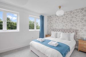 une chambre avec un lit et deux fenêtres dans l'établissement The Roost Group - 5 Bed House Hot Tub & Pool Table, à St. Leonards