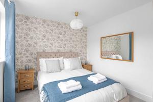 une chambre avec un lit avec des serviettes dessus dans l'établissement The Roost Group - 5 Bed House Hot Tub & Pool Table, à St. Leonards