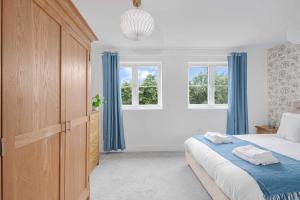 - une chambre blanche avec des rideaux bleus et un lit dans l'établissement The Roost Group - 5 Bed House Hot Tub & Pool Table, à St. Leonards 27 autres photos