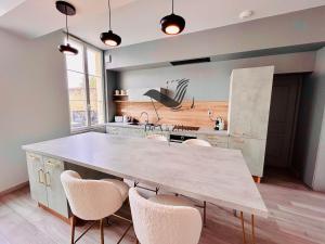 eine Küche mit einem großen Tisch und einigen Stühlen in der Unterkunft République 5 - Downtown & close to thermal baths in Rochefort