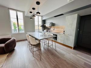 une cuisine avec une table et des chaises dans une pièce dans l'établissement République 5 - Downtown & close to thermal baths, à Rochefort