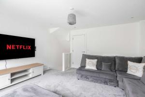 a living room with a couch and a flat screen tv at The Roost Group - 5 Bed House Hot Tub Near Beach in St. Leonards