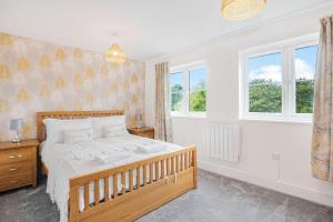 a bedroom with a bed and two windows at The Roost Group - 5 Bed House Hot Tub Near Beach in St. Leonards +40 photos