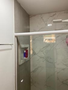 サン・ミゲル・ドス・ミラーグレスにあるCasa 2 quartos com área verde AnaManô Suitesのガラスドア付きのシャワー付きのバスルーム