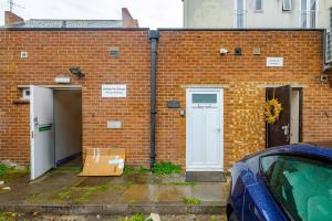 a brick building with a door and a car parked outside at The Burleigh palace in Cambridge