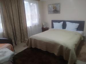 Un dormitorio con una cama blanca grande y una ventana en Nino Apartement Zugdidi, en Zugdidi