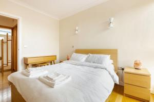 a bedroom with a white bed with towels on it at The Cambridge Penthouse in Cambridge