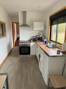 a kitchen with a stove and a dishwasher at Casinha do codecal in Labruja