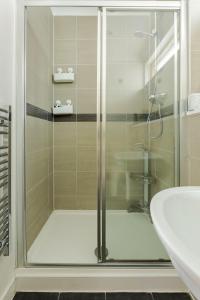 a glass shower in a bathroom with a sink at The Cambridge Penthouse in Cambridge