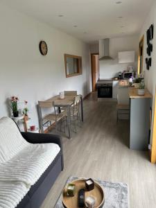 a living room and kitchen with a couch and a table at Casinha do codecal in Labruja +2 photos