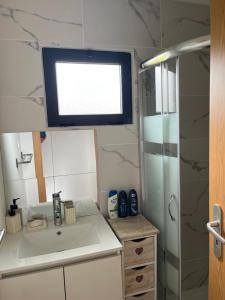 a small bathroom with a sink and a shower at Casinha do codecal in Labruja