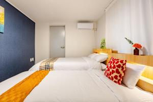 ein Schlafzimmer mit zwei Betten mit weißer Bettwäsche in der Unterkunft Bins Heim AB101 in Samgong-ni