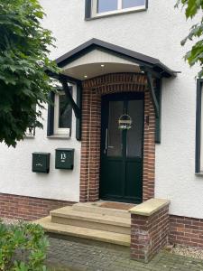a front door of a white house with a green door at Monteurwohnung in ruhiger Lage in Spechtholzhock