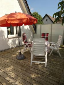 a patio with a table and chairs and an umbrella at Monteurwohnung in ruhiger Lage in Spechtholzhock