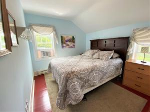 ein Schlafzimmer mit einem großen Bett und zwei Fenstern in der Unterkunft UP Cottage in Saint Ignace