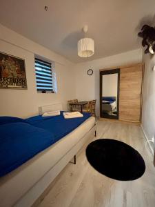 een slaapkamer met een blauw bed, een tafel en een spiegel bij Elephant Studio in Wrocław